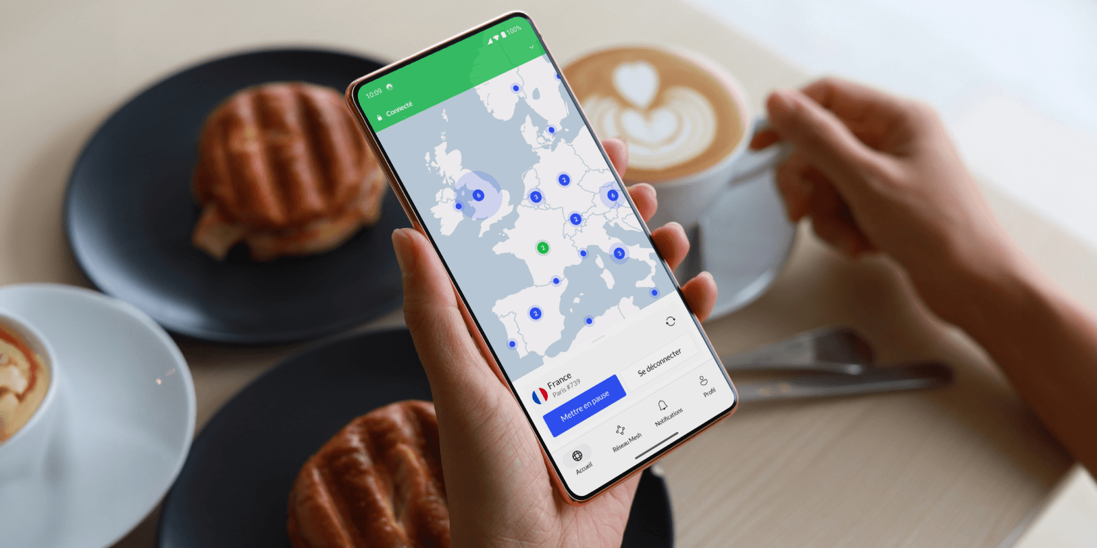 Smartphone affichant l'application NordVPN connectée à un serveur en France, tenu au-dessus d'une table de café