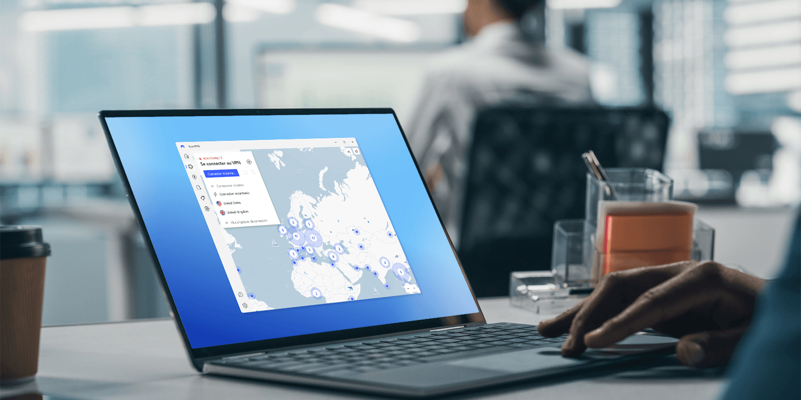 Ordinateur portable affichant l'application NordVPN pour Windows sur un bureau, dans un espace de travail partagé